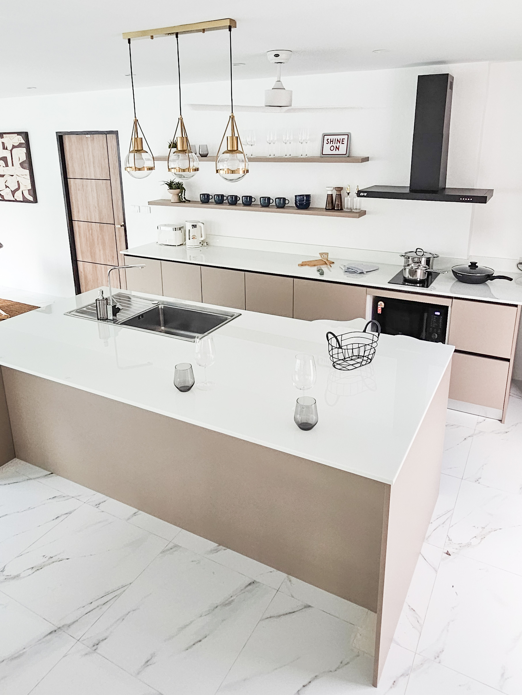 NaY Yang Villa kitchen with a white island and brass pendant lights